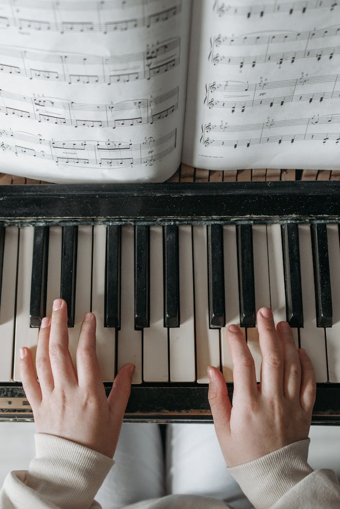 why-choose-us Child playing piano with sheet music above, focusing on hand placement and notes.